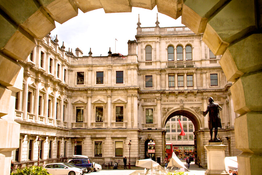 Looking through an archway at a historic building with timber sash windows
